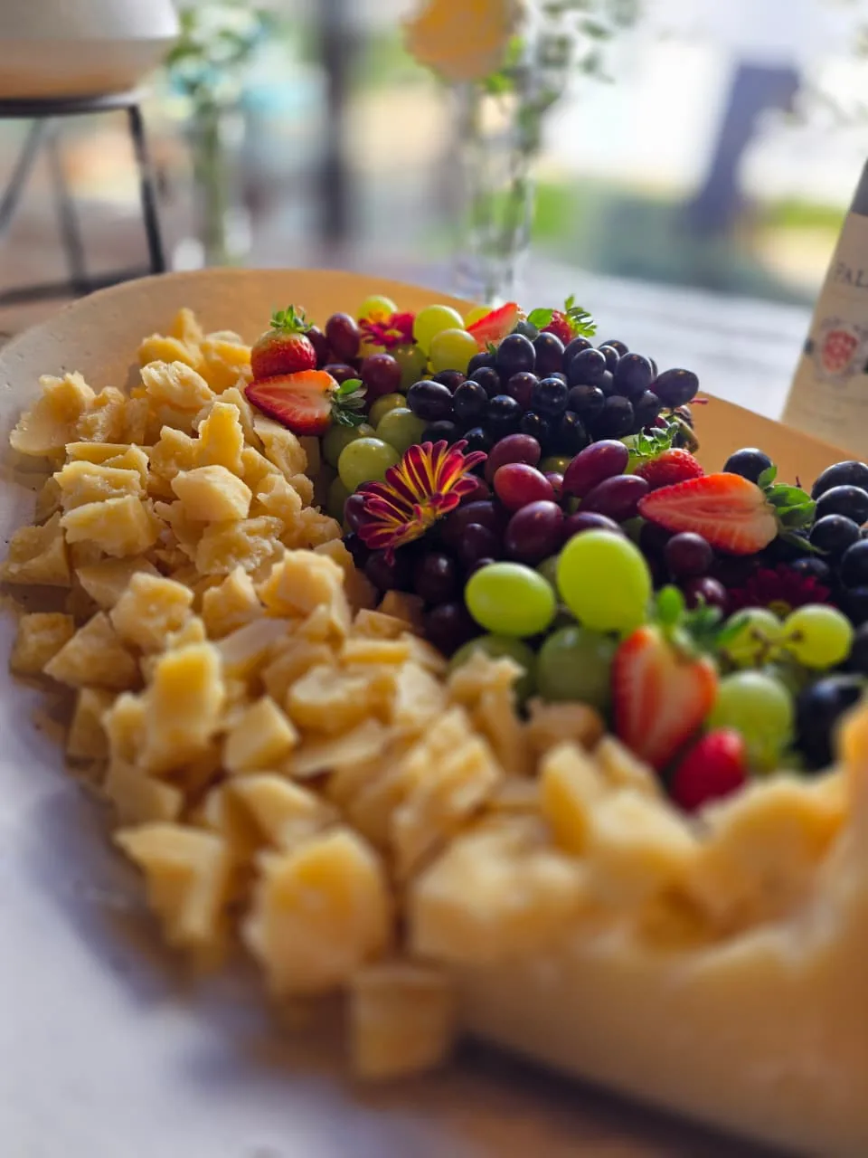 Tábua de queijos artesanais com uvas, morangos e flores comestíveis
